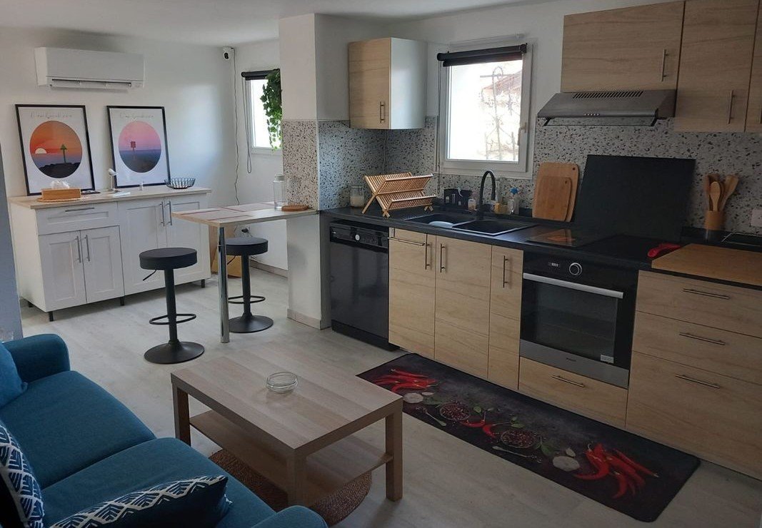 Cuisine ouverte entièrement équipée et salon climatisé de l'appartement Les Bruyères, Mimizan-Plage